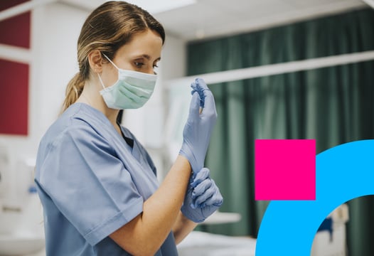 Mujer auxiliar en enfermería en formación se coloca guantes para práctica clínica.