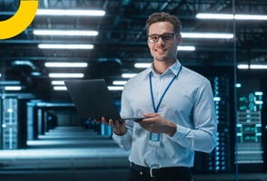 Un joven sosteniendo su portátil y validando las herramientas de codificación de software.