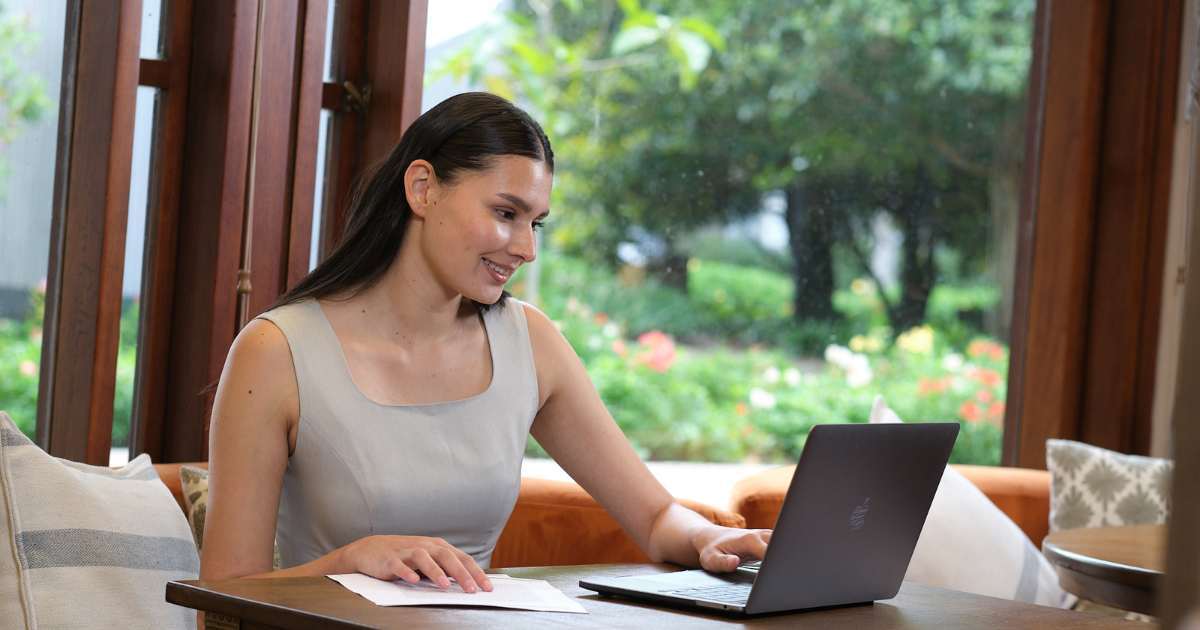 Mujer estudia uno de los programas de la CET en su computador portátil. 